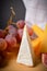 Close up of Cheeseboard platter with hard and soft mould cheese, grape and segmented fig on wooden board