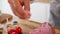 A close-up of a chef adding spices into a piece of meat