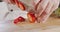 Close up of a chef knife slicing a strawberry