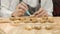 Close up of Chef placing Christmas homemade gingerbread tree cookies on wooden tray