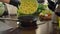 Close-up of chef pouring oil in frying pan and cooking vegetables in kitchen