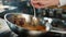 Close-up: Chef pouring sauce over filet mignon while cooking