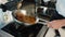 Close-up: Chef pouring sauce over filet mignon while cooking