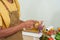 Close-up chef\\\'s hand-making breakfast, male chef wearing apron and both hands holding vegetable peeler, which has peel,