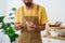 Close-up chef\\\'s hand-making breakfast, male chef wearing apron and both hands holding vegetable peeler, which has peel,