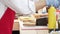 Close-up of a chef`s hands in gloves preparing delicious sandwiches with pastrami, pickles and cheese outdoors.