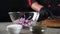 close-up of a chef\'s hands pouring sliced onion into a transparent bowl. Salad cooking concept.