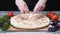 Close-up of chef`s hands in silicone gloves adding cheese to the pizza on a wooden table. Frame. Delicious pizza