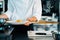 Close-up: chef serving french omelette on plate before serving in a restaurant in a professional kitchen