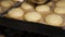 Close-up of the chef using a brush to apply egg mixture to round burger buns.