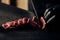 Close-up of a chef wearing black gloves expertly slicing meat