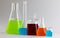 Close up of chemistry beakers and dishes with liquid and copy space on white background