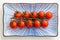 Close up cherry tomatoes on a ceramic rectangle plate