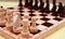 Close-up chess pieces stand in a row on the board. Black and white figures of different designations.
