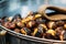 Close up of chestnuts on a pan with a salesman