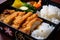 Close-up of chicken katsu bento box with rice, pickles, and miso soup