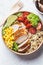 Close-up of chicken and quinoa salad with corn and tomatoes in craft eco bowl. Zero waste, to go food, recycling packaging, eco