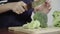 Close up of chief woman making salad healthy food and chopping broccoli on cutting board