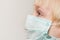 Close up of child face in surgical mask, white background. Prevention of bacterial infection Covid 19