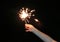 Close-up child hand holding fire sparklers on the dark at festival