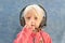 Close-up of a child in headphones shows something with his fingers