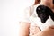 Close Up Of Child Holding Miniature Black And White Flop Eared Rabbit On White Background