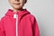 Close-up of a child in a pink jumpsuit or sweatshirt with a zipper, headless photo. Shoulders, neck.