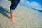 Close up of child`s feet walking on crystal clear tropical sea water.