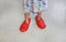 Close up child`s feet wearing adult slippers at home