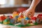 Close-up of a child\\\'s hand assembling colorful building blocks to create a miniature town