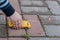 Close-up of a child`s hand driving a small toy car on the cobblestones. Idea - children`s games, development of imagination in