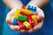 Close-up of child\\\'s hands holding an assortment of multicolored building blocks, emphasizing creativity and playful learning