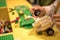 Close up of child`s hands playing with colorful plastic bricks at the table. Early learning. stripe background. Developing toys