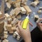 Close-up of child`s hands playing with wooden constructor, bricks on table. Boy glues blocks to make house, building