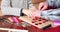 Close-up of children and elderly hands making handmade cards by laying out hearts on paper. Love, family and Valentine`s day