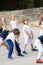 Close up of children group warming up and preparing for the main part of lesson. Sport school