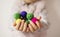 Close up of children hands holding colorful felt balls. Child, kid palms. A little girl keep in handfuls of colored wool balls