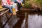 Close Up Of Children\'s Feet Dangling From Wooden Bridge