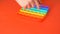 Close-up of a children`s hand pressing on a colorful pop it. The child enjoys playing pop it. Popular children`s board game. Selec