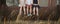 Close up of children`s legs, three siblings sitting on a rusty pipe