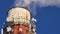 Close-up of a chimney with cellular antennas emitting thick white smoke.