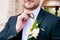A close-up of the chin of a bearded stylish groom. To correct a butterfly with a buttonhole in the frame