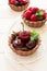 Close up of chocolate tartlets with chocolate cream, fresh strawberries, raspberries, blueberries, red currants and cherries