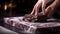 A close-up of a chocolatier\'s hand gently spreading Couverture Chocolate onto a marble slab