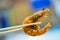 Close up chopsticks keep on the fried shrimp with blurred background.