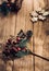 Close up of Christmas mistletoe leaf and pine cone on wood plank table with sunlight through window