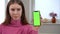 Close-up chromakey smartphone in hand of dissatisfied young woman shaking head. Portrait of unsatisfied Caucasian