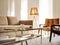 Close up of chrome coffee table near beige sofa and orange chair against window. Mid-century home interior design of modern living