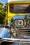 Close-up on the chrome radiator grille, headlight and mud guard of a filipino Jeepney in the Philippines.