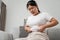 Close up of chubby woman holding her belly fat on the sofa. Diet lifestyle to reduce belly and shape up healthy, abdominal muscle